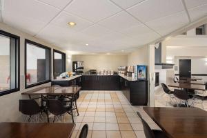 een keuken en eetkamer met tafels en stoelen bij Super 8 by Wyndham Sainte Agathe Des Monts in Sainte-Agathe-des-Monts