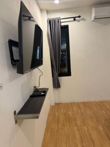 a room with a tv and a mirror on a wall at โรงแรมช้างใหญ่ใจดี in Yasothon +18 photos
