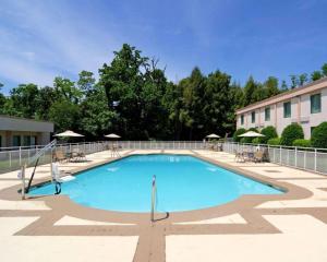 a large swimming pool with chairs and umbrellas at Comfort Inn Monticello in Charlottesville