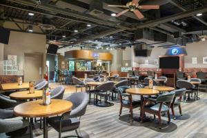 Un restaurante con mesas y sillas en una sala. en Days Inn & Conference Centre by Wyndham Camrose Norsemen, en Camrose