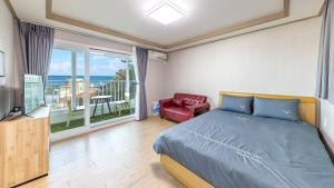 a bedroom with a bed and a view of the ocean at Gangneung Glad Pension in Gangneung