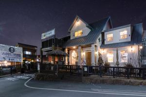 a house with lights on in a parking lot at night at Gyeongju Sweetcreamhill Pension in Gyeongju