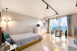 a bedroom with a bed and a table with chairs at Yeosu Harushimpyo Pension in Yeosu