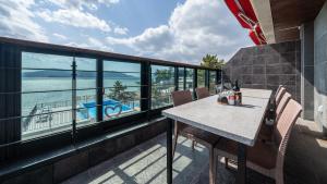 a balcony with a table and chairs and a boat at Sacheon Bichae Pension in Sacheon