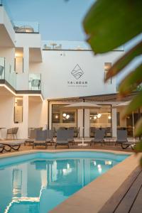 a swimming pool in front of a hotel at Saladar Suites Boutique in Morro del Jable