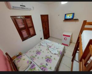 a room with a bed and a television in it at Pousada Chalet La Pink in Canoa Quebrada