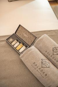 a box of cosmetics sitting on a bed with towels at Saladar Suites Boutique in Morro del Jable