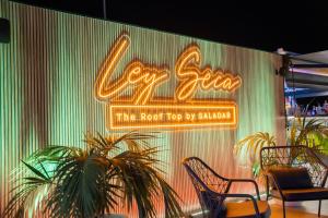 a neon sign on the side of a building at Saladar Suites Boutique in Morro del Jable