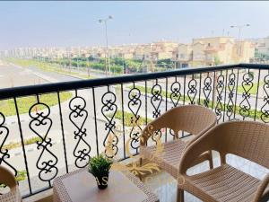 balkon z dwoma krzesłami i stołem na balkonie w obiekcie Casa Do Cairo-AlRehab w mieście Burg el-Ḥudûd