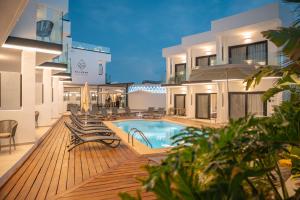 a building with a pool and chairs on a deck at Saladar Suites Boutique in Morro del Jable