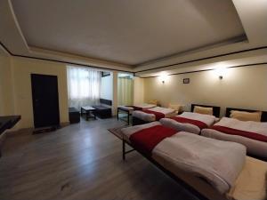 una habitación con 4 camas y una habitación con mesas en Lingmoo Residency, en Ravangla 18 fotos más