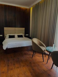 a bedroom with a bed and a table and a chair at Dyal Resorts in Phagwāra +9 photos