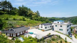 江陵市Gangneung ggabinejip hanok pension的享有村庄的空中景致,拥有房屋和树木