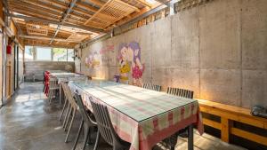 江陵市Gangneung ggabinejip hanok pension的一间设有桌椅的房间和墙上的绘画