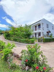 a white house with flowers in front of it at Majani Breeze in Nungwi