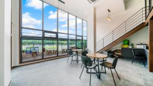 a room with tables and chairs and a large window at Gapyeong Sungshine Pension in Gapyeong