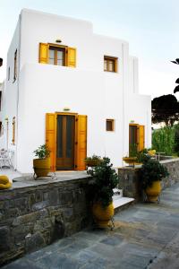 a white building with yellow doors and potted plants at Alisachni in Serifos Chora
