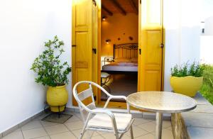 a patio with a table and chairs and a bedroom at Alisachni in Serifos Chora