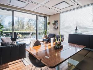 a living room with a wooden table and chairs at AquaHome - NP de Biesbosch - Bijzonder overnachten op een houseboat! in Werkendam
