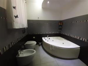 a bathroom with a large tub and a toilet at TONNARA HOUSE AND HOLIDAY in Avola +26 photos