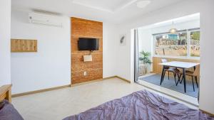 a living room with a table and a tv in it at Namhae JJhouse Pension in Namhae