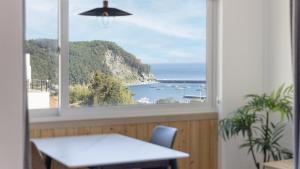 a window with a view of the ocean at Namhae JJhouse Pension in Namhae