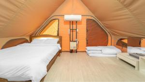 a bedroom with two beds in a tent at Goseong Bluebeach Pension&Glamping in Goseong