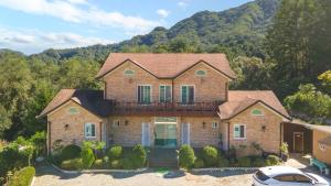 a large brick house with a car parked in front of it at Gapyeong Ashely Pension in Gapyeong
