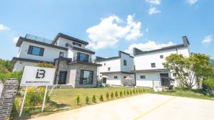 a large white house with a sign in front of it at Gyeongju Blibli Poolvilla in Gyeongju +13 photos