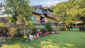 a house with a bunch of toy motorcycles and a playground at Namyangju HAIMOM Family Pension Black in Namyangju