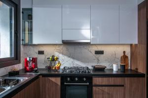 a kitchen with white cabinets and a stove top oven at Savvy Apartments in Áyioi Dhéka