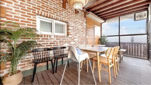 a dining room with a table and chairs on a balcony at Namyangju HAIMOM Family Pension Black in Namyangju +25 photos