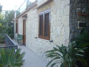 a stone building with a window and a green bench at B&B Villa Ursa Major in Vico Equense