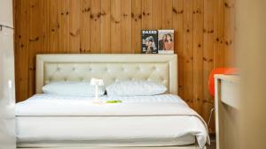a white bed in a room with a wooden wall at Gapyeong Haneuldari pet pension in Gapyeong +7 photos