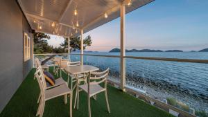 a table and chairs on a balcony overlooking the water at Yeosu Baraboda Ocean View Pension in Yeosu +12 photos