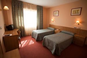 a hotel room with two beds and a window at Hotel Restaurante La Alhama in Medina de Pomar +59 photos