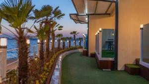 a resort hallway with palm trees and the ocean at Yeosu Baraboda Ocean View Pension in Yeosu