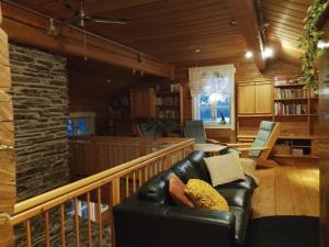 Una sala de estar con un sofá de cuero negro. en Arctic house, en Rovaniemi