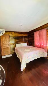 una camera da letto con un letto con copriletto rosa di New Klong Khong Garden a Ko Lanta