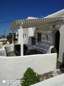 una casa blanca con una pérgola blanca en Sigalas House, Sikinos Island, en Síkinos