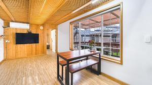 a dining room with a table and a large window at jeju bijalim pension in Jeju