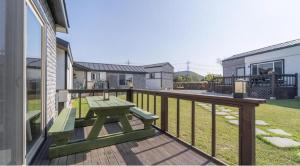 a wooden deck with a picnic bench on a balcony at jeju bijalim pension in Jeju