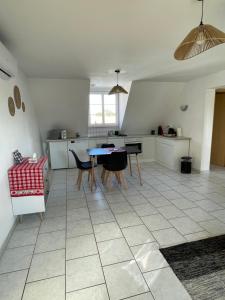 a kitchen with a table and chairs on a tiled floor at Appartement Betschdorf Cité des potiers in Oberbetschdorf +2 photos