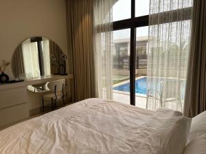 Un dormitorio con una cama y vistas a una piscina. en Luxury Redefined in Hawana Salalah, en Salalah 107 fotos más