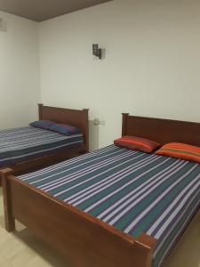 two beds sitting next to each other in a bedroom at Florish Holiday Resort in Kataragama