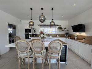 a kitchen with a table with chairs and a counter at Le Luxury - 24h du Mans - 11pers - Rêve au Mans in Ruaudin