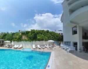 ケメルにあるKaftans City Hotel by RRH&Rの大きなスイミングプール(椅子付)