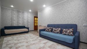 a living room with two blue chairs and a couch at НОМАД 3-ком Апартаменты в центре in Petropavlovsk
