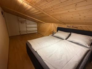 a bed in a small room with a wooden ceiling at Hotel Bergglück in Filzmoos