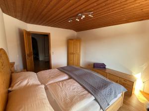 a bedroom with a bed and a wooden ceiling at Hotel Bergglück in Filzmoos